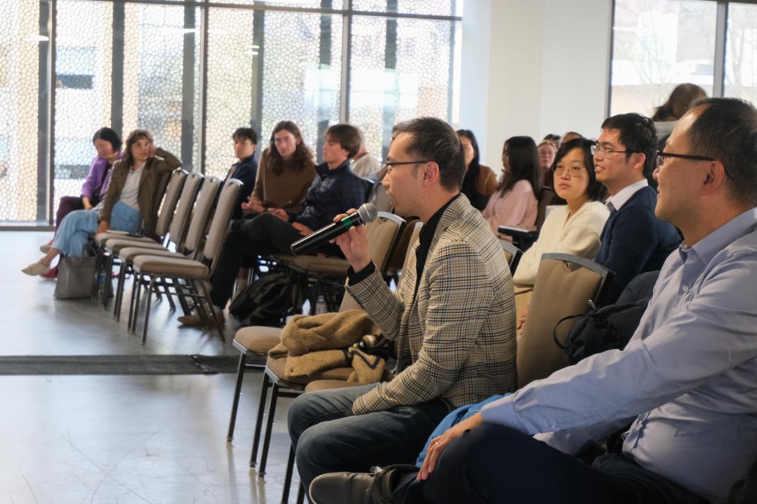 Faculty member speaks into a microphone 